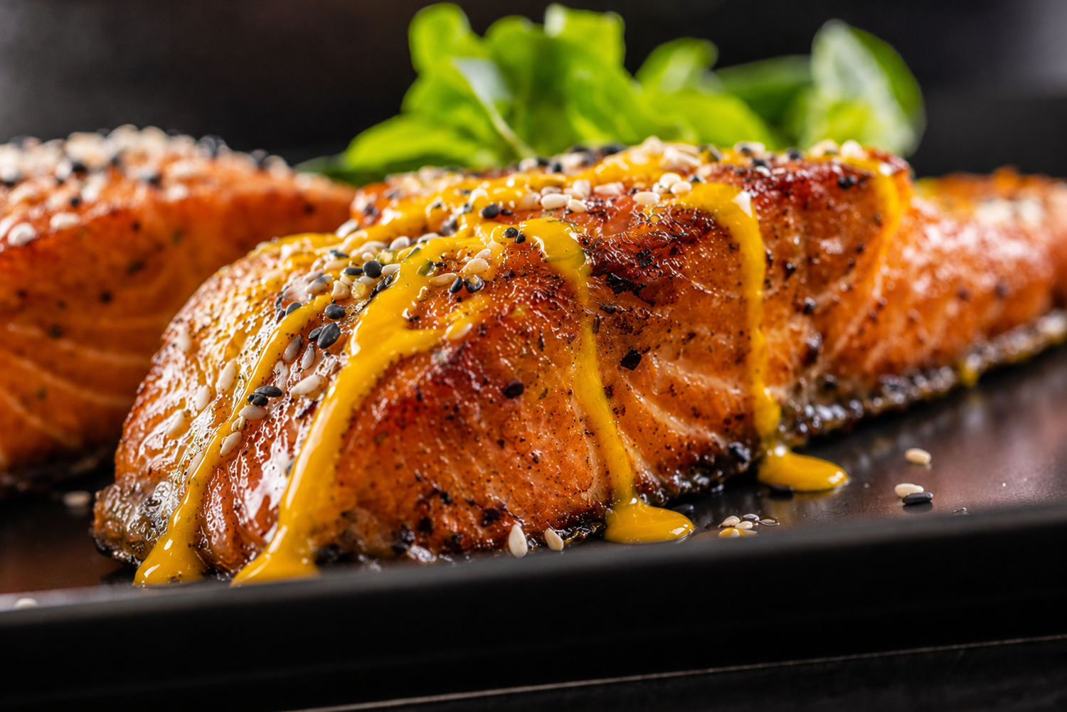 Grilled salmon with Jersdey Girl Horseradish mustard sauce on a black plate